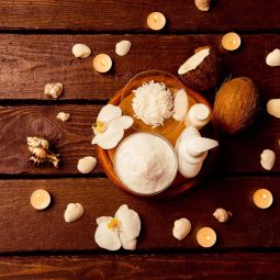 Spa setting with cosmetic lotion, gel, bath salt, candles and coconut on  wooden background